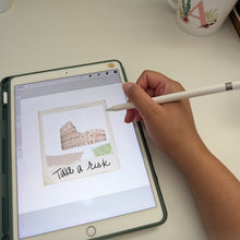 Load image into Gallery viewer, A person's hand holding a white stylus over a tablet case on a white desk, displaying a watercolor sketch of the Colosseum with the handwritten text 'Takes a Risk'. A white mug filled with pens is visible in the background.