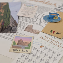 Load image into Gallery viewer, A styled flat-lay of a September Habit Tracker card set, featuring a habit tracker sheet with cocktail glass icons, a small 'Take a risk' card, a blue coffee cup sticker, and a brown envelope on a white background.
